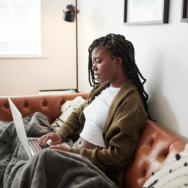 Black women on sofa using laptop