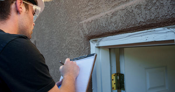 Workman inspecting cracks in a wall
