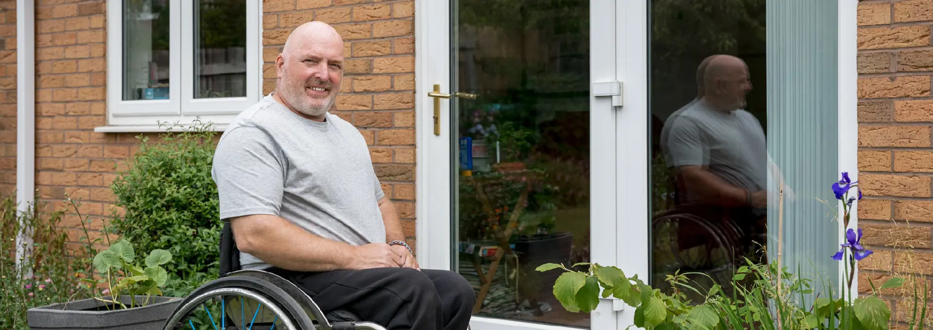 Man in wheelchair outside his home