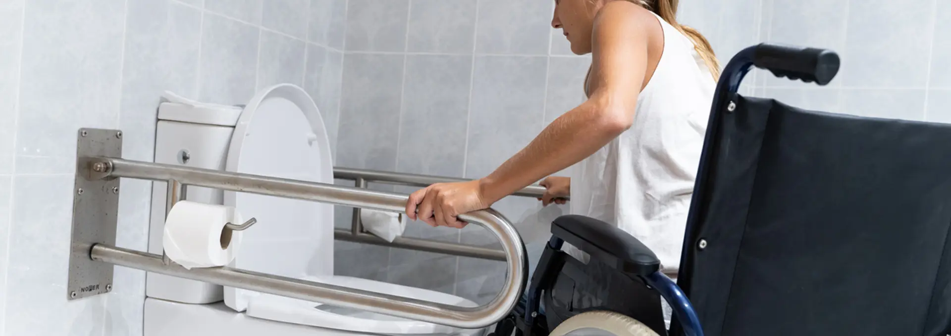 Women in wheelchair using grab rails - stock