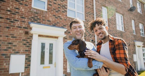 Couple outside new home with dog - stock