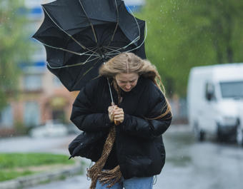 Blonde woman under umbrella. Storm weather