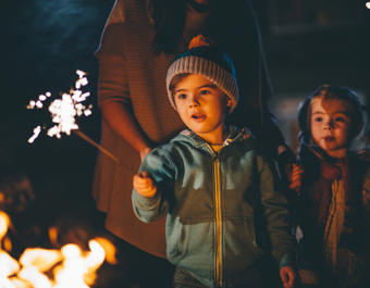 Young boy holding a sparkler on Bonfire Night